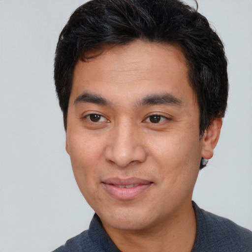 Joyful asian young-adult male with short  black hair and brown eyes
