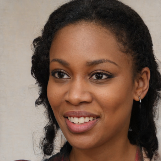 Joyful black young-adult female with long  black hair and brown eyes