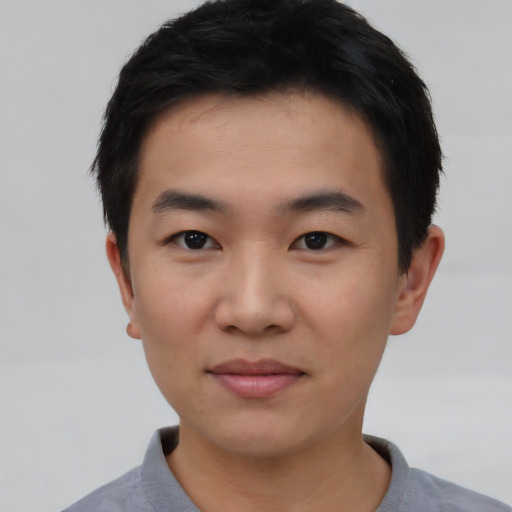 Joyful asian young-adult male with short  black hair and brown eyes