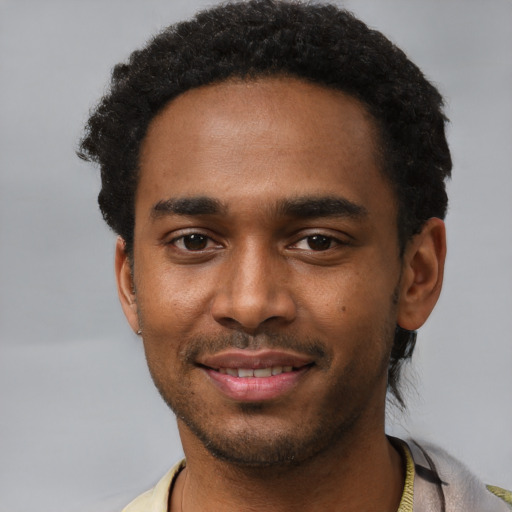 Joyful black young-adult male with short  black hair and brown eyes