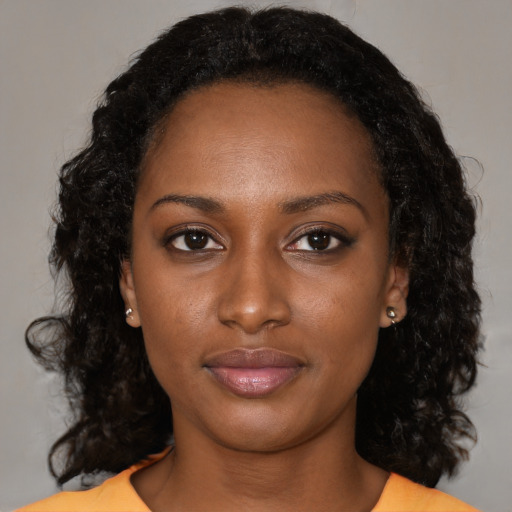 Joyful black young-adult female with medium  black hair and brown eyes