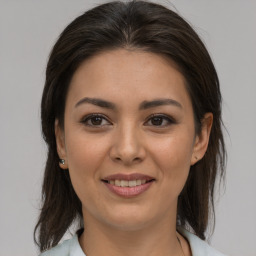 Joyful latino young-adult female with medium  brown hair and brown eyes