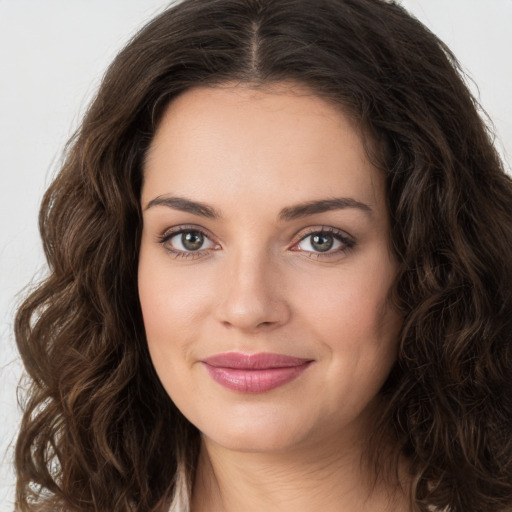 Joyful white young-adult female with long  brown hair and green eyes