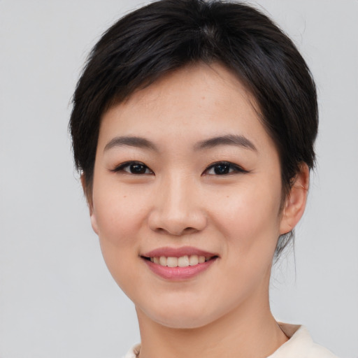 Joyful asian young-adult female with short  brown hair and brown eyes