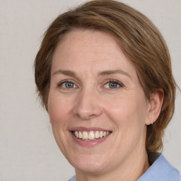 Joyful white adult female with medium  brown hair and blue eyes