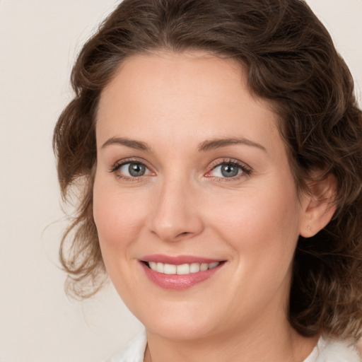 Joyful white young-adult female with medium  brown hair and green eyes