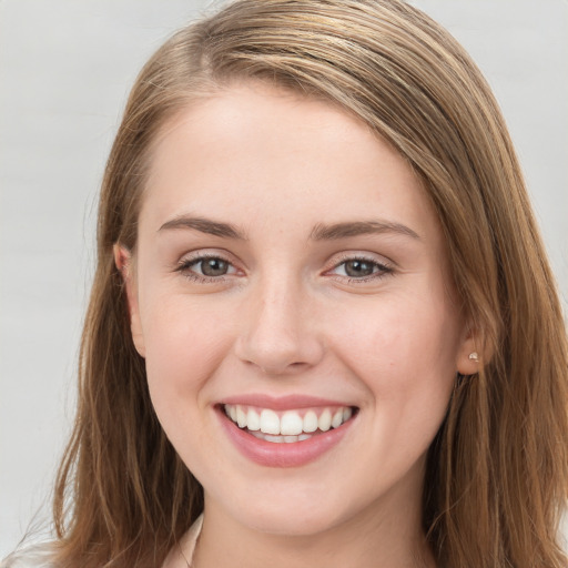 Joyful white young-adult female with long  brown hair and blue eyes