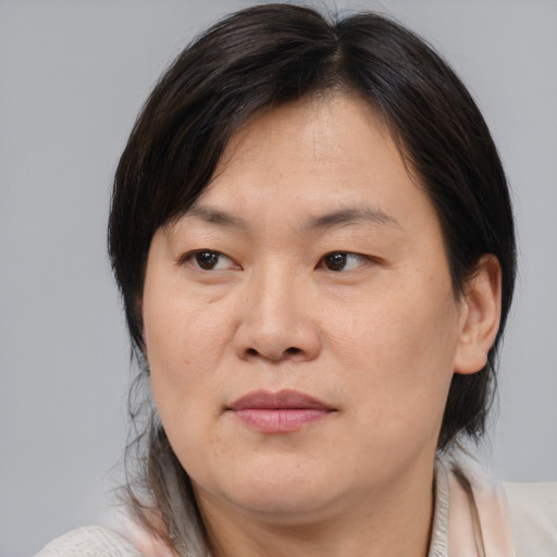 Joyful asian adult female with medium  brown hair and brown eyes