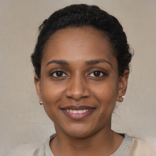 Joyful black young-adult female with short  black hair and brown eyes