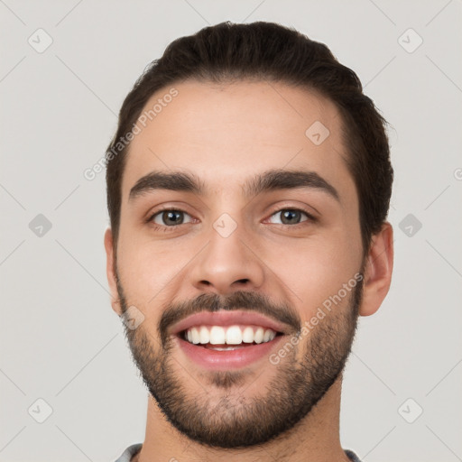 Joyful white young-adult male with short  black hair and brown eyes