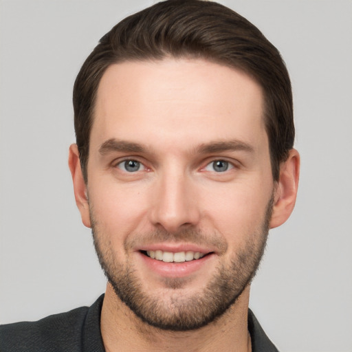 Joyful white young-adult male with short  brown hair and grey eyes