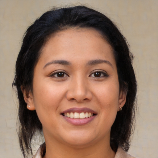 Joyful latino young-adult female with medium  brown hair and brown eyes