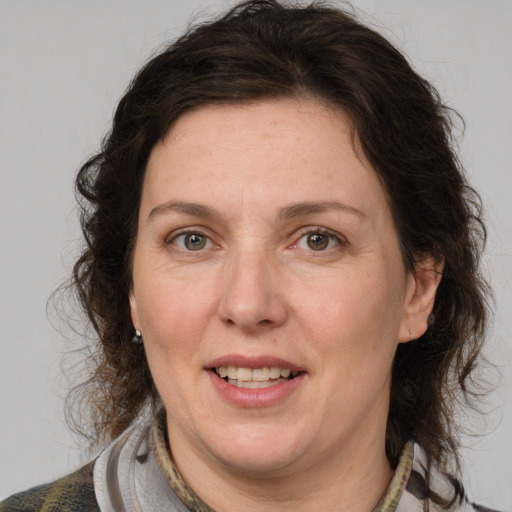 Joyful white adult female with medium  brown hair and grey eyes