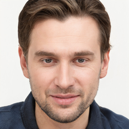 Joyful white young-adult male with short  brown hair and grey eyes