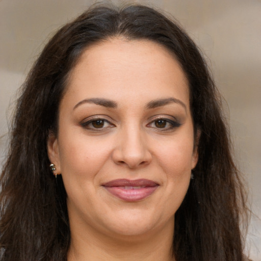Joyful white adult female with long  brown hair and brown eyes