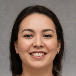 Joyful white young-adult female with long  brown hair and brown eyes