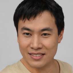 Joyful asian young-adult male with short  brown hair and brown eyes