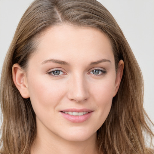 Joyful white young-adult female with long  brown hair and blue eyes