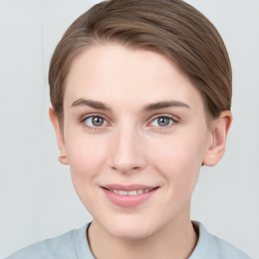 Joyful white young-adult female with short  brown hair and grey eyes