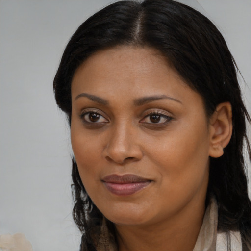 Joyful black young-adult female with long  brown hair and brown eyes