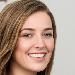 Joyful white young-adult female with long  brown hair and green eyes