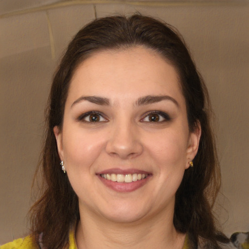 Joyful white young-adult female with long  brown hair and brown eyes