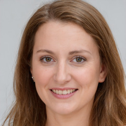 Joyful white young-adult female with long  brown hair and green eyes