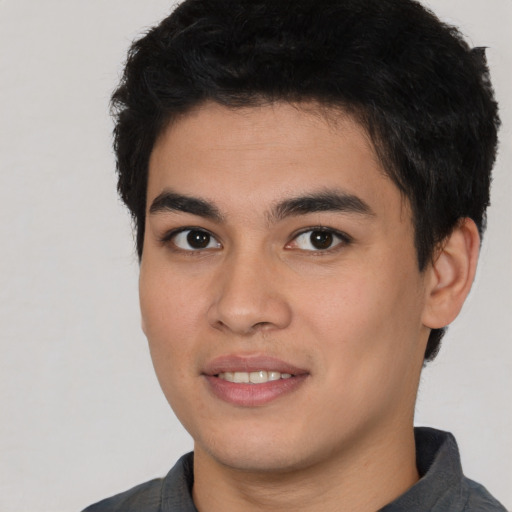 Joyful latino young-adult male with short  black hair and brown eyes