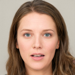 Joyful white young-adult female with long  brown hair and blue eyes