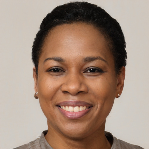 Joyful black adult female with short  black hair and brown eyes