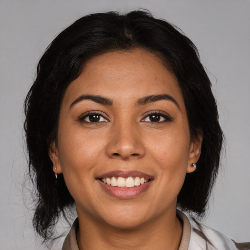Joyful latino young-adult female with medium  brown hair and brown eyes