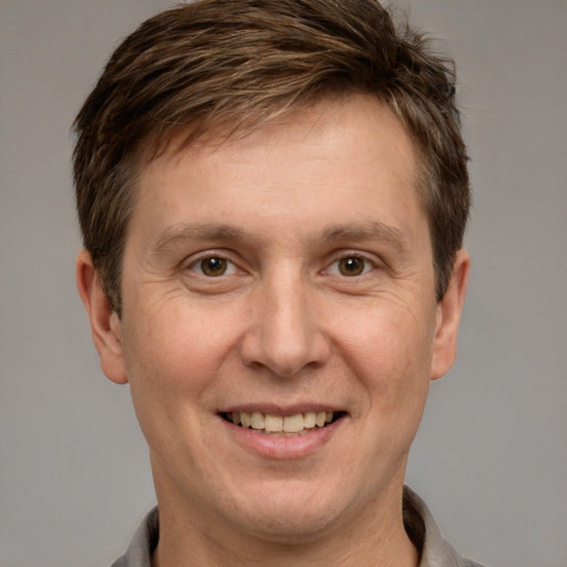 Joyful white adult male with short  brown hair and grey eyes