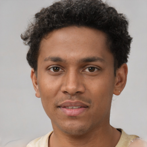 Joyful black young-adult male with short  brown hair and brown eyes