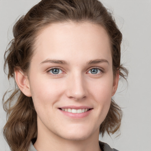 Joyful white young-adult female with medium  brown hair and blue eyes