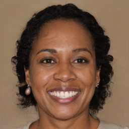 Joyful black adult female with long  brown hair and brown eyes