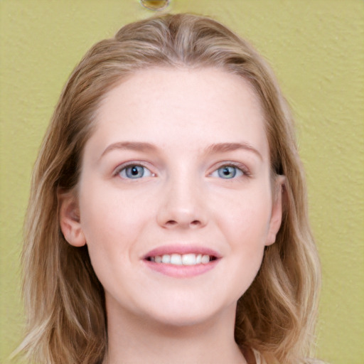 Joyful white young-adult female with long  brown hair and blue eyes