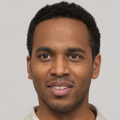Joyful black young-adult male with short  black hair and brown eyes