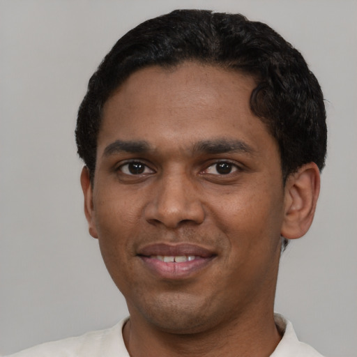 Joyful black young-adult male with short  black hair and brown eyes