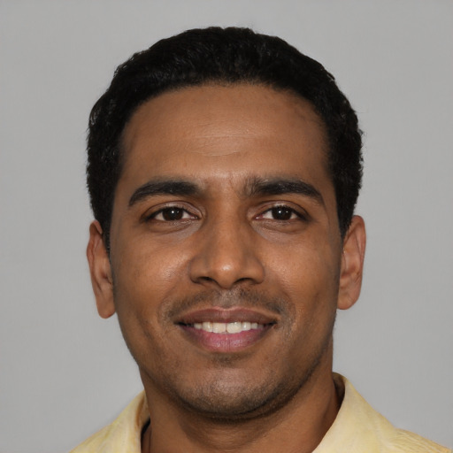 Joyful black young-adult male with short  black hair and brown eyes