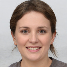 Joyful white young-adult female with medium  brown hair and grey eyes