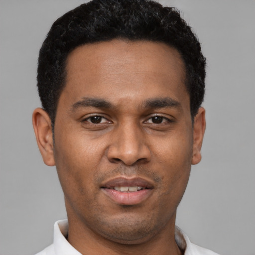 Joyful latino young-adult male with short  black hair and brown eyes