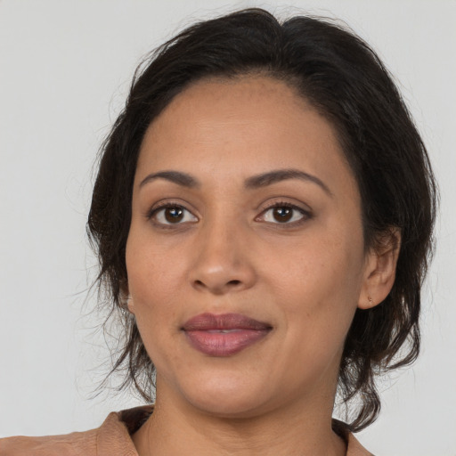 Joyful latino young-adult female with medium  brown hair and brown eyes