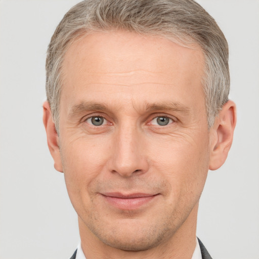 Joyful white adult male with short  brown hair and grey eyes