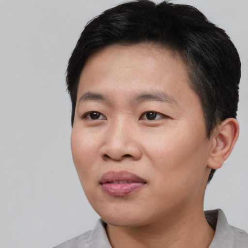Joyful asian young-adult male with short  black hair and brown eyes