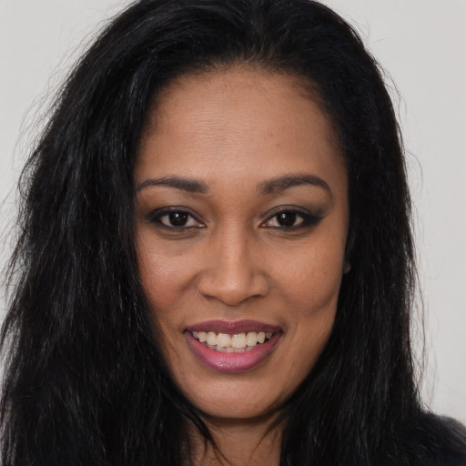 Joyful black young-adult female with long  brown hair and brown eyes