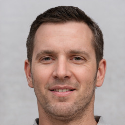 Joyful white adult male with short  brown hair and grey eyes