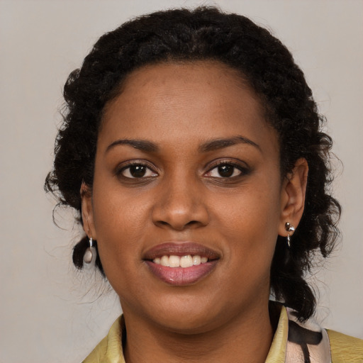 Joyful black young-adult female with long  brown hair and brown eyes