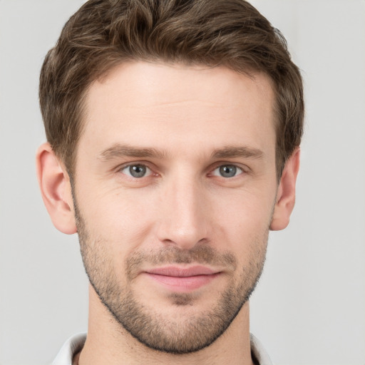 Joyful white young-adult male with short  brown hair and grey eyes