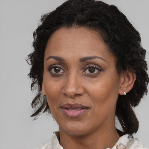 Joyful black adult female with medium  brown hair and brown eyes