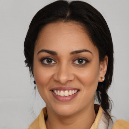 Joyful latino young-adult female with medium  brown hair and brown eyes